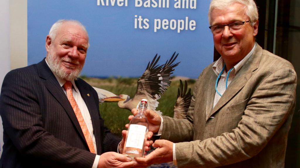 Incoming ICPDR President Helge Wendenburg and Peter Gammeltoft pose with bottle of Danube water
