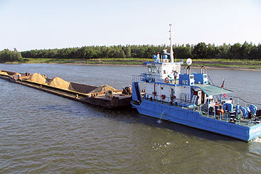 a boat floating along a river next to a body of water