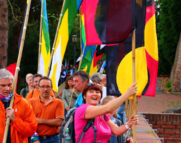 a group of people standing next to a colorful kite