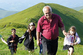 © Olena Marushevska a group of people in a field with a mountain in the background