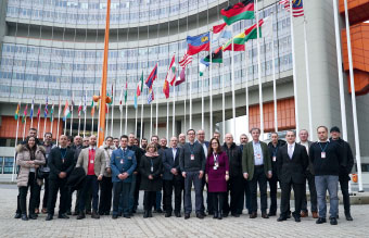 © DAREnet a group of people standing in front of flags and the UN building in Vienna