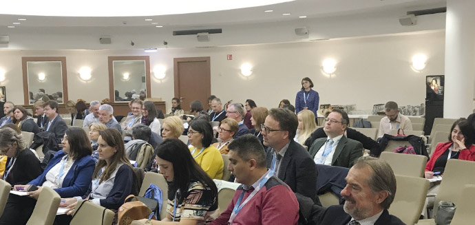 a group of people sitting at a desk in front of a crowd