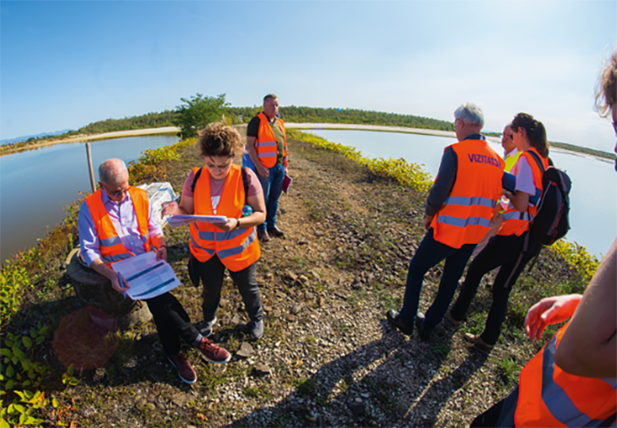 a group of people standing next to a body of water