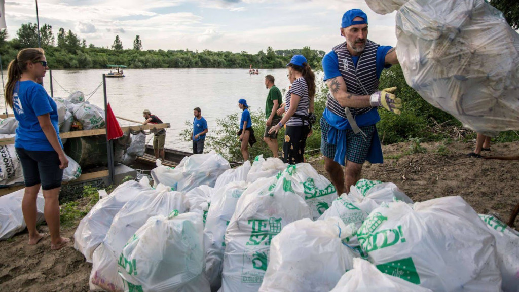© PET CUP volunteers put collected plastic bottle waste in trash bags