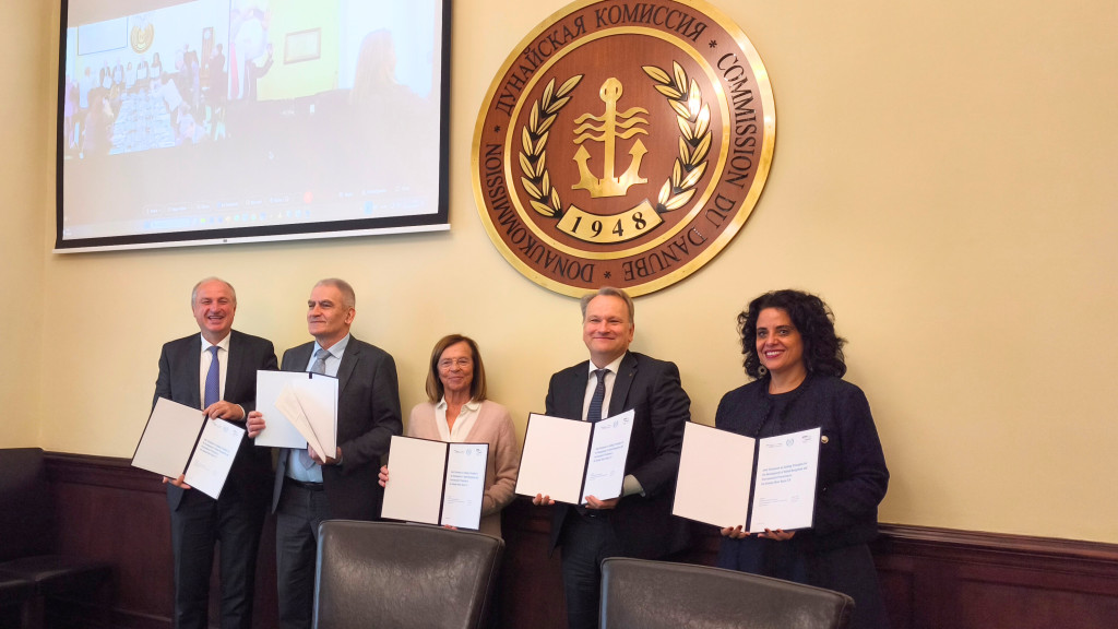 Five representatives hold up copies of the Joint Statement 2.0 document.