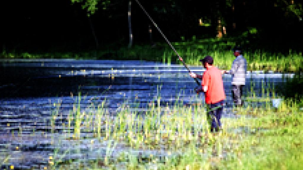 a man standing next to a lake