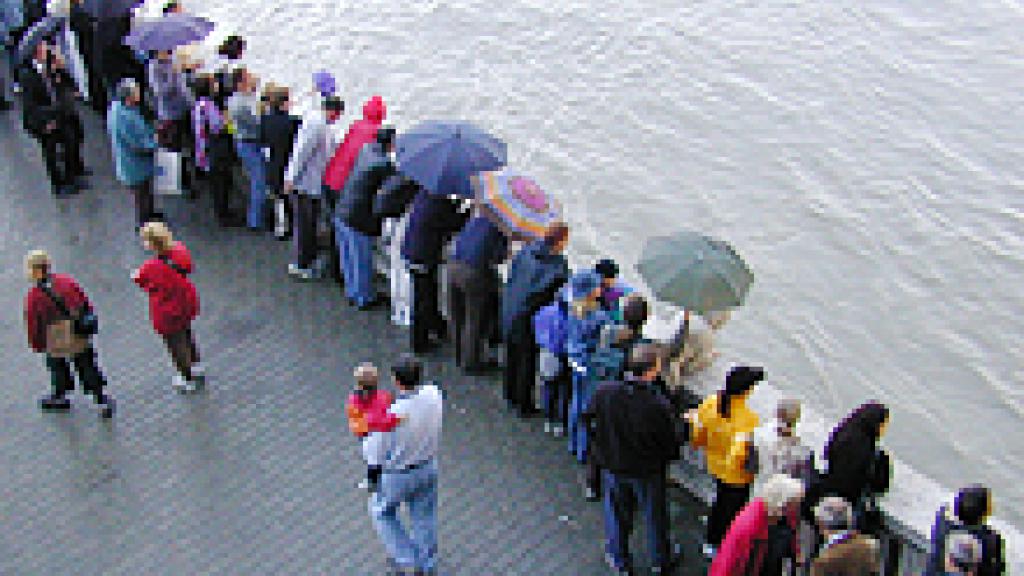 A crowd of people over looking a body of water 