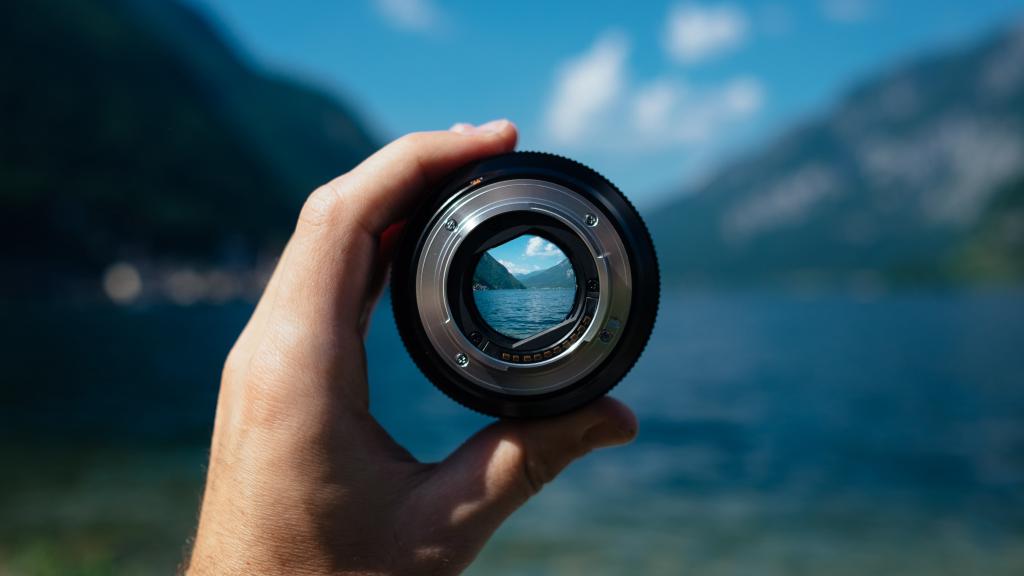 a hand holding a camera lense