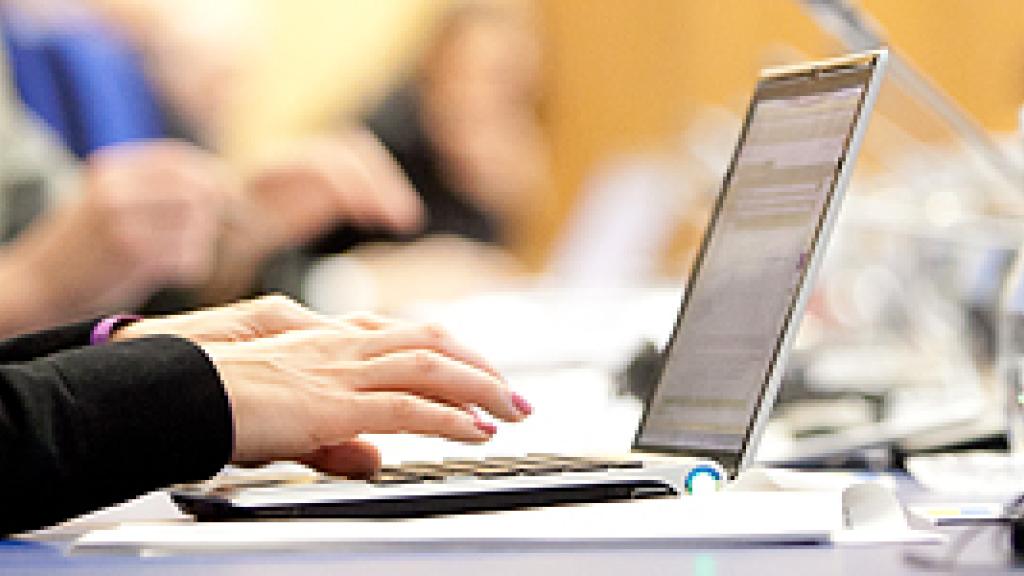 Person sitting at a table using a laptop 