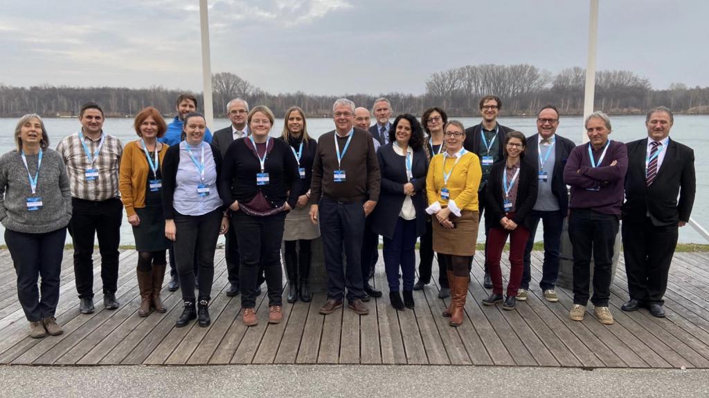 Stakeholder members pose for a photo in front of river 