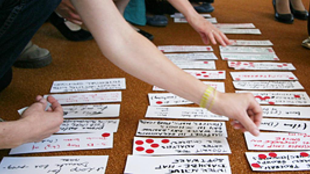 hands of people sorting sheets of paper