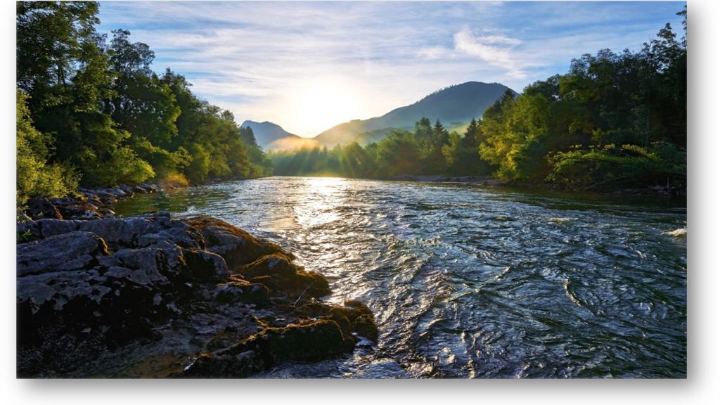 Flowing river with mountain range in the background.