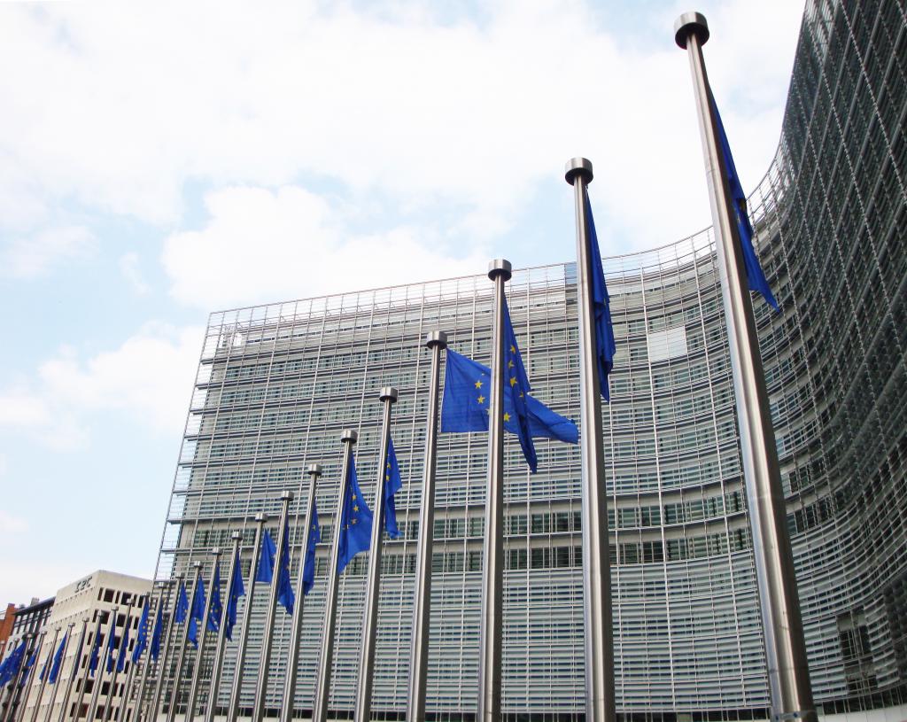 View of the facade of the European Commission building in Brussels, with EU flags