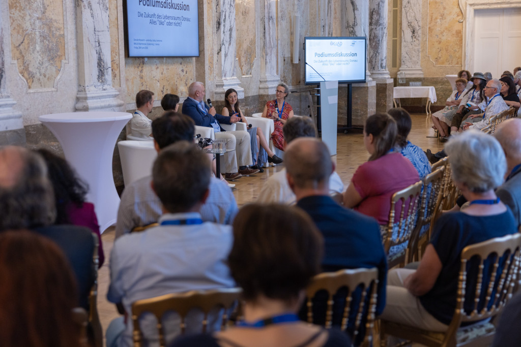 People gathered in a room, facing a panel