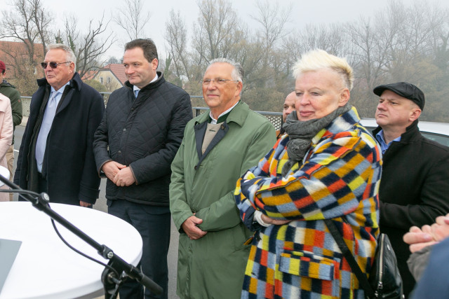 People standing and watching by the water