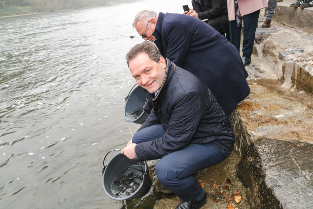 a man releasing a fish into the water 