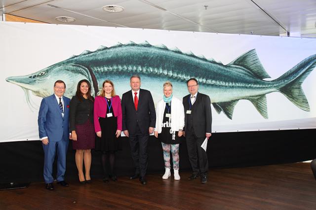 a group of people standing in front of a fish posing for the camera