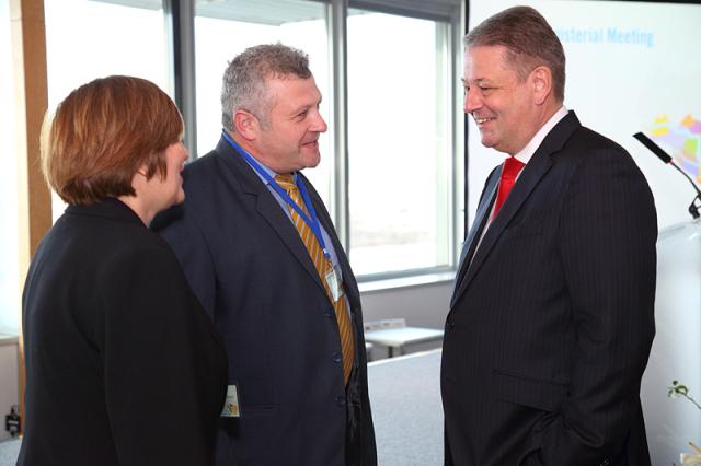 a group of people standing next to a man in a suit and tie