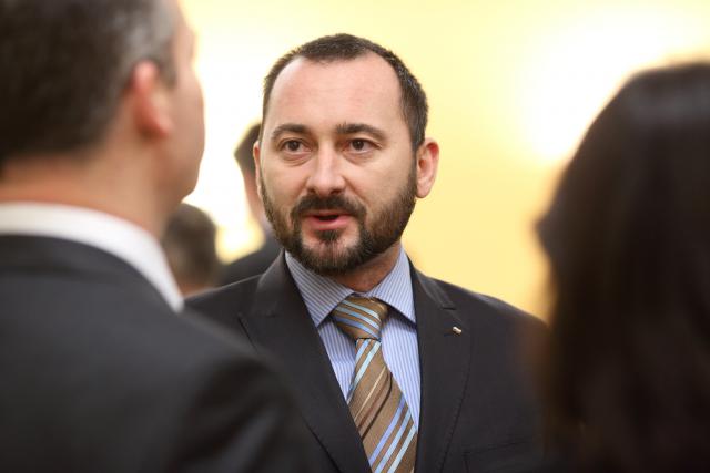 a man wearing a suit and tie looking at the camera