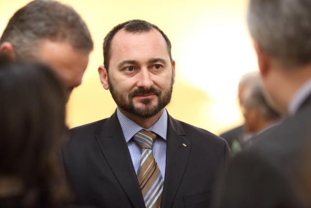 a man wearing a suit and tie looking at the camera