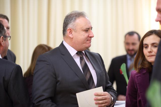 a group of people looking at a man in a suit and tie