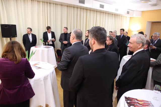 a group of people standing around a table