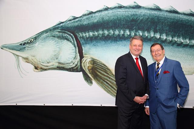 a man standing in front of a fish