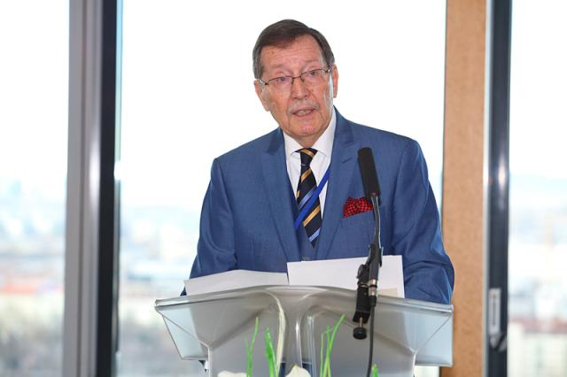 a man in a suit standing in front of a window