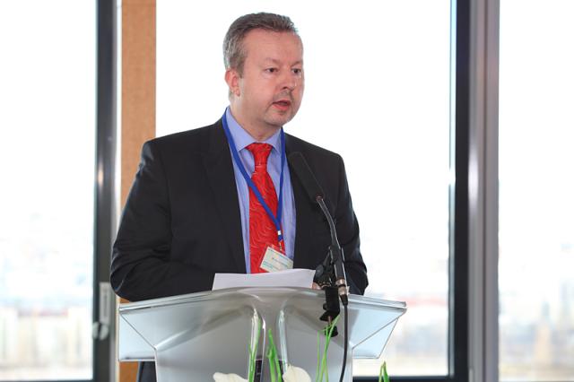 a man wearing a suit and tie in front of a window