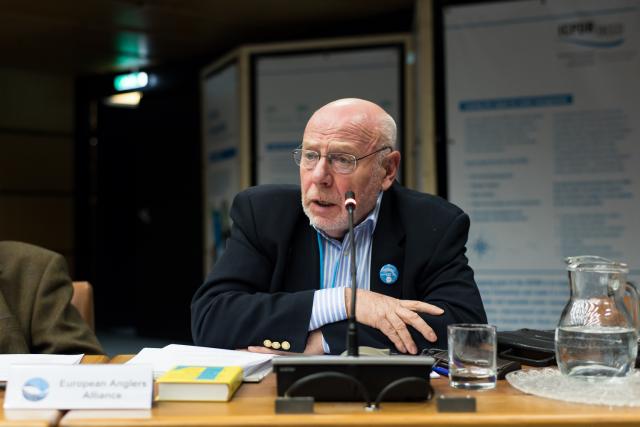 a man sitting at a table with wine glasses