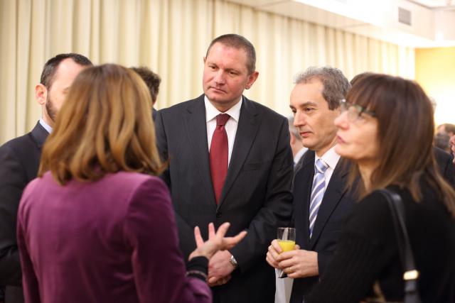 a group of people standing next to a person in a suit and tie