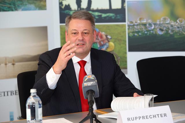 a man wearing a suit and tie sitting at a table