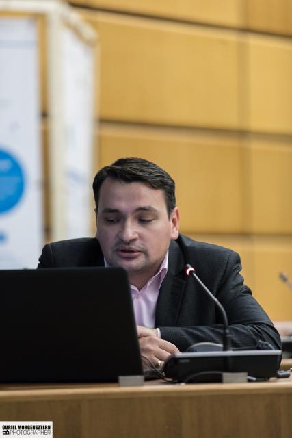 a man sitting at a table using a laptop