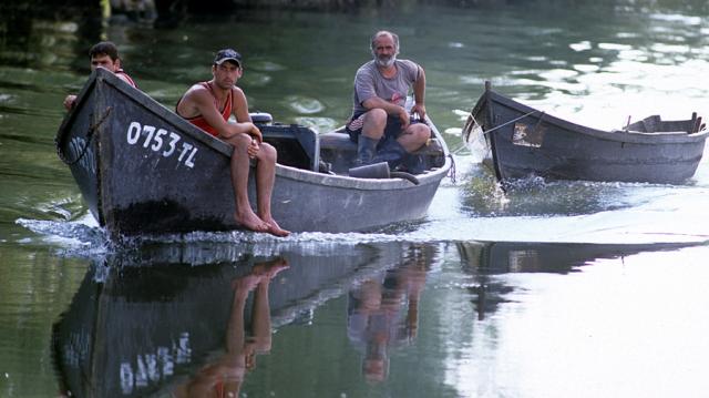 a group of people in a small boat in a body of water