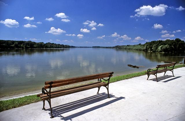 empty park benches next to a body of water