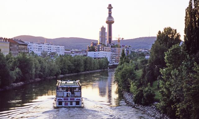 a small boat in a body of water with a city in the background