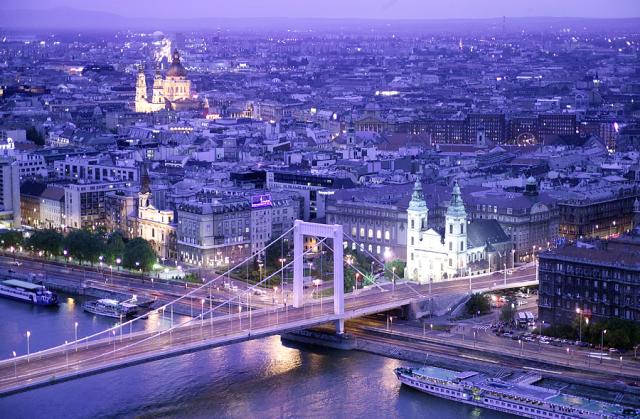 a bridge over water with a city in the background