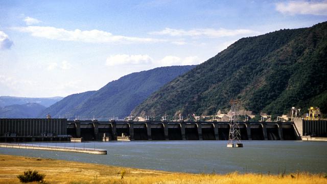 a bridge over a body of water with a mountain in the background