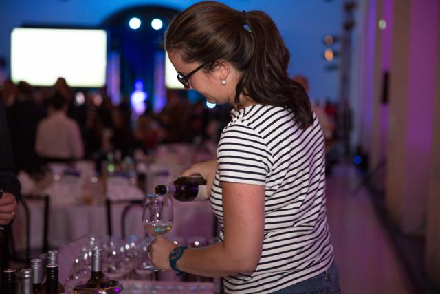 a woman sitting at a table with wine glasses