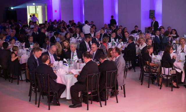 a group of people sitting at a table in front of a crowd