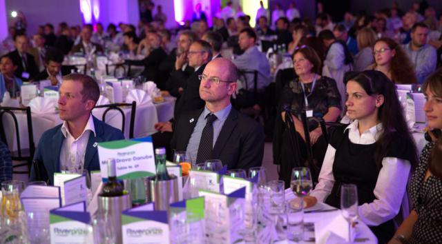 a group of people sitting at a table in front of a crowd