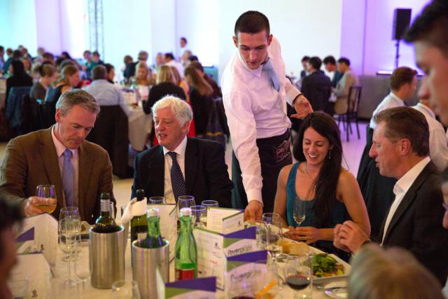 a group of people sitting at a table in front of a crowd