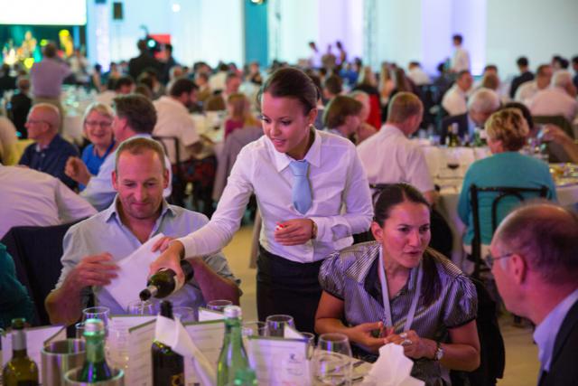 a group of people sitting at a table in front of a crowd