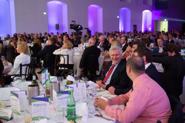 a group of people sitting around a long table