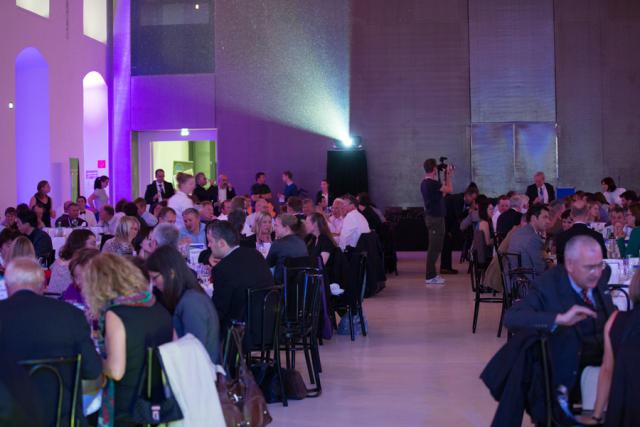 a group of people sitting at a table in front of a crowd