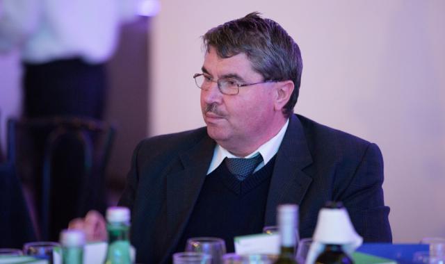 a man wearing a suit and tie sitting at a table