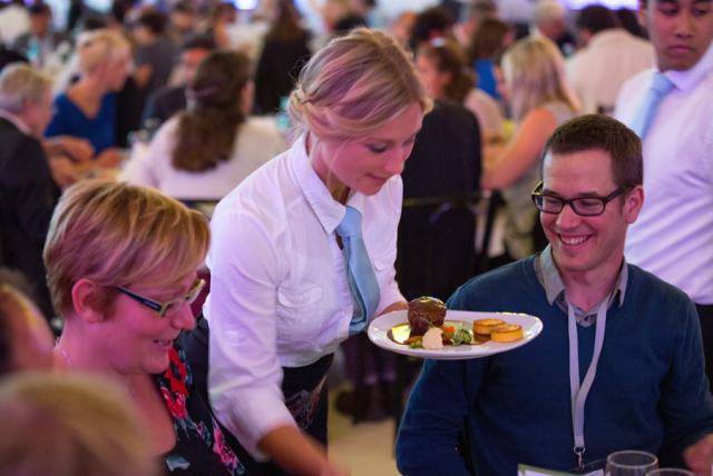 a group of people sitting at a table in front of a crowd