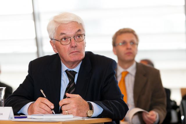 a man wearing a suit and tie sitting at a table