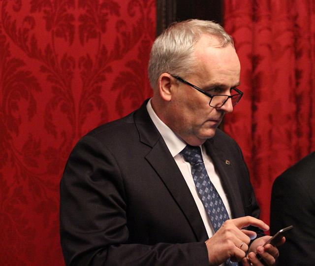 a man wearing a suit and tie talking on a cell phone