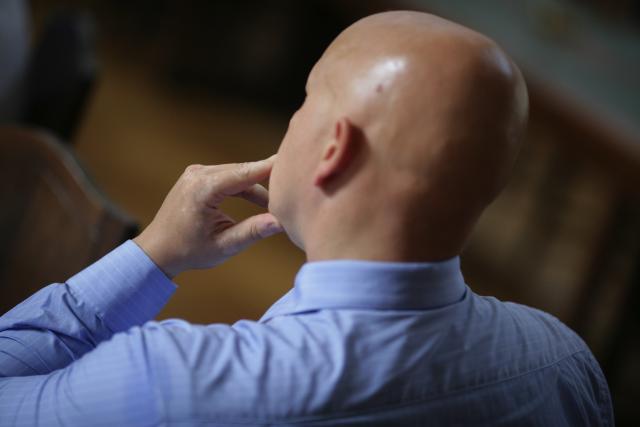 a close up of a man in a blue shirt